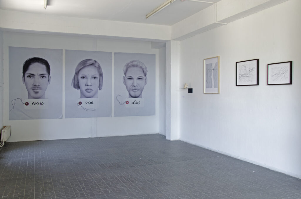 vue de l'exposition avec de grands portraits robotos et des oeuvres encadrées au mur