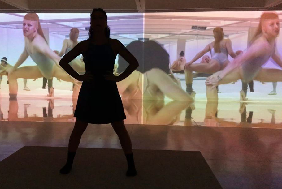 Une ombre de corps devant une vidéo-projection de danse