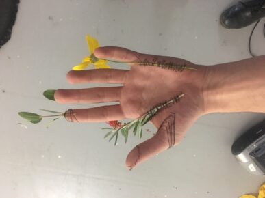 vue d'une main ouverte ornée de fleurs et de tiges