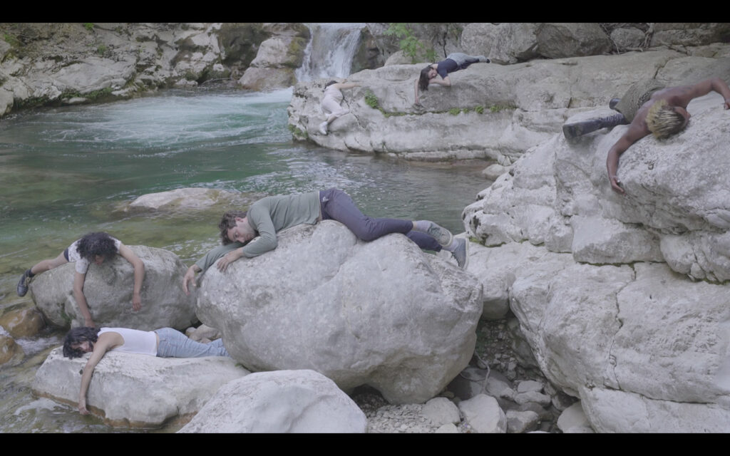 des corps endormis allongés sur des rochers au bord d'une rivière