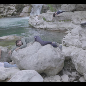 des corps endormis allongés sur des rochers au bord d'une rivière