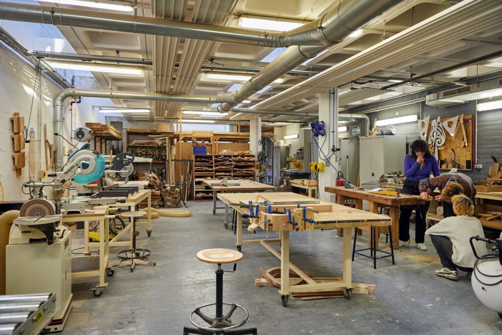 vue large de l'atelier bois avec des étudiant·es au travail