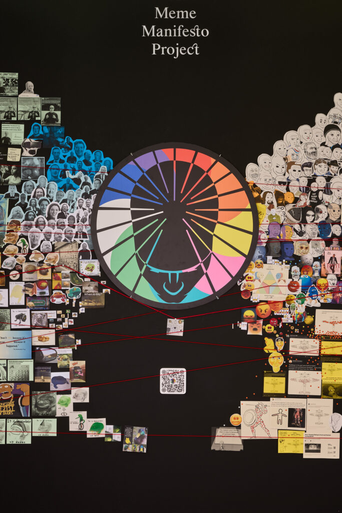 Vue de face du centre de l'exposition dont le centre est un symbole coloré par lequel sont reliés tous les mèmes