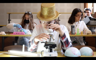 Un enfant regarde dans un microscope. Il a un chapeau doré