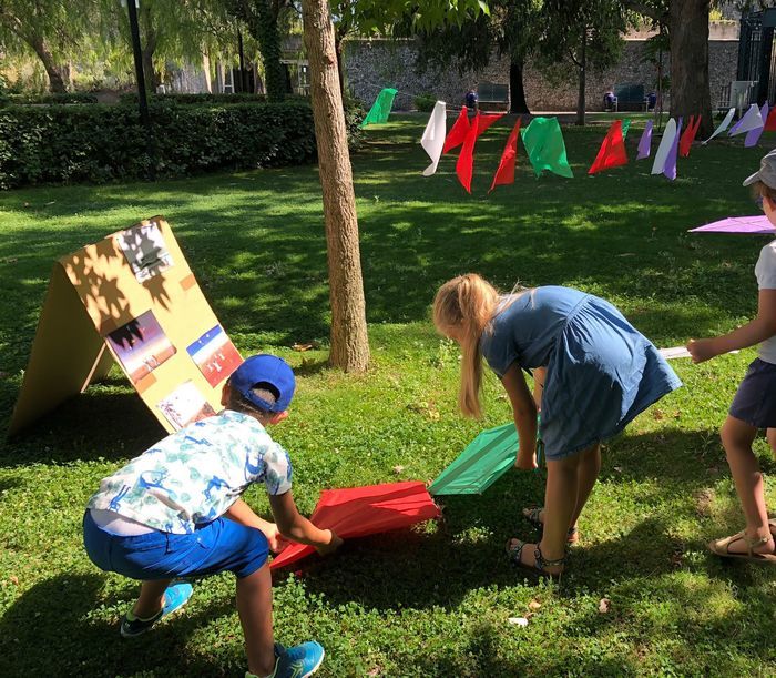des enfants dans l'herbe tenant des affiches de couleurs