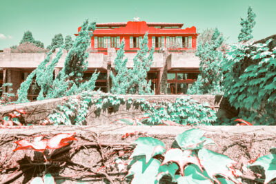 Une villa rouge, de la végétation très verte, du béton gris